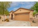 Single-story home featuring desert landscaping, a spacious driveway, and an attached two-car garage at 18374 W Stinson Dr, Surprise, AZ 85374