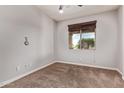 Neutral-toned bedroom with plush carpet, window with blinds and a ceiling fan at 23728 W Magnolia Dr, Buckeye, AZ 85326