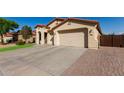 Charming home featuring a low-pitched red tile roof, neutral stucco, and a spacious driveway with a three car garage at 27089 N 172Nd Ln, Surprise, AZ 85387