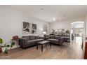 Inviting living room with wood-look floors, neutral walls, and abundant natural light pouring in, creating a warm ambiance at 27089 N 172Nd Ln, Surprise, AZ 85387