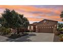 Charming home exterior with stone accents, mature landscaping, and circular driveway at 27926 N 130Th Ave, Peoria, AZ 85383