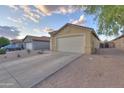 Exterior view of a home with a spacious driveway and two-car garage in a residential neighborhood at 40054 W Tamara Ln, Maricopa, AZ 85138