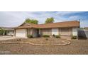 Charming home with desert front yard, brick accents, and a white garage door with front entrance at 402 W Mohawk Ln, Phoenix, AZ 85027