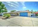 Attractive brick home featuring a well-manicured desert yard and a bright blue garage door at 4023 W Joan De Arc Ave, Phoenix, AZ 85029