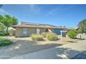 Inviting single-story home with manicured desert landscaping, solar panels, and a blue garage door at 4023 W Joan De Arc Ave, Phoenix, AZ 85029