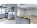 Open kitchen featuring gray cabinets, stainless steel appliances, a kitchen island, and adjacent dining area at 4023 W Joan De Arc Ave, Phoenix, AZ 85029