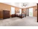 A spacious main bedroom features a ceiling fan, neutral walls and carpet with outdoor access at 4125 W Lydia Ln, Phoenix, AZ 85041