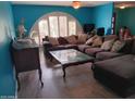 Inviting living room featuring a large comfortable sectional couch and unique arched window at 4549 W Seldon Ln, Glendale, AZ 85302