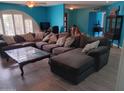 Spacious living room with a cozy sectional sofa, accent pillows and a distinctive glass-top coffee table at 4549 W Seldon Ln, Glendale, AZ 85302