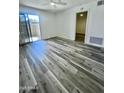 Bright living room featuring sleek gray wood flooring and sliding glass door to the balcony at 533 W Guadalupe Rd # 1110, Mesa, AZ 85210