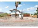 Two-story bright white house with desert landscaping, including a palm tree, set against a partly cloudy sky at 5599 S Alameda Rd, Gold Canyon, AZ 85118