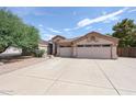 Front exterior view with desert landscaping, spacious driveway, and attached two-car garage with decorative details at 656 W Johnson Dr, Gilbert, AZ 85233