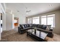 Bright living room featuring plush carpet, a ceiling fan, and a large sectional sofa for comfortable seating at 656 W Johnson Dr, Gilbert, AZ 85233