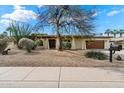Inviting single-story home with desert landscaping, mature trees, and a charming front entrance at 6711 E Presidio Rd, Scottsdale, AZ 85254