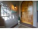 Inviting front entrance featuring a solid wood door, decorative lighting, and a welcoming atmosphere at 7517 E Mariposa Grande Dr, Scottsdale, AZ 85255
