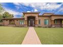 Stunning single-story home featuring a beautiful lawn, brick walkway, and an elegant covered entryway with wooden accents at 823 W Palo Verde Dr, Phoenix, AZ 85013