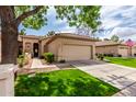 Inviting single-story home featuring a well-kept lawn and a convenient two-car garage at 9717 E Holiday Way, Sun Lakes, AZ 85248