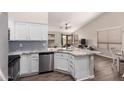 Stylish kitchen with white cabinets, stainless steel appliances, and an island overlooking the living area at 9717 E Holiday Way, Sun Lakes, AZ 85248