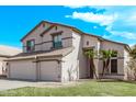 Two-story home featuring a three-car garage, neutral stucco, and desert-friendly landscaping at 11317 W Cottonwood Ln, Avondale, AZ 85392