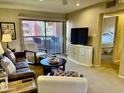 Comfortable living room with a balcony, a TV, and views leading into a bedroom at 12222 N Paradise Village Pkwy # 321, Phoenix, AZ 85032