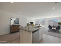 A modern kitchen island with a sink overlooks an open floorplan living and dining area at 1304 W Inca Dr, Coolidge, AZ 85128