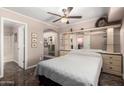 Bright bedroom showcasing tile floors, a ceiling fan, and an en-suite bathroom at 1440 N Idaho Rd # 2053, Apache Junction, AZ 85119