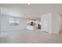Spacious living room and kitchen area with white walls, recessed lighting, and tiled floor at 15585 W Williams St, Goodyear, AZ 85338