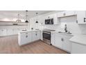 Modern kitchen with stainless steel appliances, white cabinets, and quartz countertops at 1649 W Carmel Ave, Mesa, AZ 85202