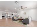 Bright and airy living room with modern decor, wood floors, and an open concept layout to the kitchen at 1649 W Carmel Ave, Mesa, AZ 85202