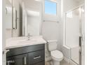 Modern bathroom with a dark vanity, white sink, shower, and tile floors at 18716 N 269Th Ln, Buckeye, AZ 85396