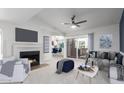 Bright living room featuring a fireplace, ceiling fan, and sliding glass door to patio at 1880 E Morten Ave # 242, Phoenix, AZ 85020