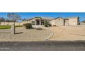 Stunning front exterior with well maintained desert landscaping and neutral colored stucco at 19535 E Via De Olivos Rd, Queen Creek, AZ 85142