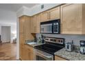 Galley kitchen featuring stainless steel appliances and light wood cabinetry with granite countertops at 2025 E Campbell Ave # 114, Phoenix, AZ 85016