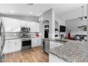 Modern kitchen with stainless steel appliances, white cabinets, granite countertops, and an open layout at 203 W Raven Dr, Chandler, AZ 85286
