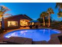 Backyard oasis featuring a sparkling blue pool, a covered patio and lush tropical landscaping for outdoor enjoyment at 203 W Raven Dr, Chandler, AZ 85286