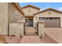 Welcoming front entrance with a wrought iron gate, paved walkway, and desert landscaping at 20340 E Camacho Rd, Queen Creek, AZ 85142