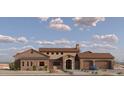 View of the front of a stone-accented home featuring a front-facing two-car garage and a light blue vehicle parked in the driveway at 21235Xxx W Elliot Rd, Buckeye, AZ 85326