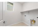 This is a view of the laundry room with connections for a washer and dryer with plenty of shelving at 21296 N 270Th Dr, Buckeye, AZ 85396