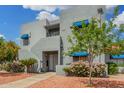 Contemporary condo building enhanced by desert landscaping, including palm trees, colorful flowers and mature shade trees at 220 N 22Nd Pl # 2041, Mesa, AZ 85213
