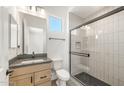 A modern bathroom featuring a walk-in shower with a black frame and a single sink vanity at 27046 W Rockwood Dr, Buckeye, AZ 85396
