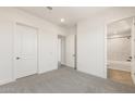 A neutral bedroom with access to an en suite bathroom and two separate closets at 27046 W Rockwood Dr, Buckeye, AZ 85396