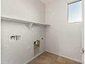 A functional laundry room with tile flooring, ample shelving, and convenient utility connections at 27110 W Adam Ave, Buckeye, AZ 85396