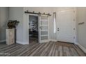 Bright foyer features wood-look floors, modern sliding barn door, and stylish decor, creating an inviting entrance at 3662 E Megan St, Gilbert, AZ 85295