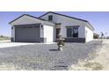 Single-story home featuring a gray two-car garage, desert landscaping, and water fountain at 3725 N Bandelier Dr, Eloy, AZ 85131
