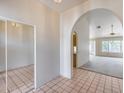 Inviting entryway with tiled floors, mirrored closet doors, and an arched doorway to the living area at 4001 E Rosemonte Dr, Phoenix, AZ 85050