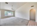Bright living room with neutral carpet, ceiling fan, vaulted ceiling, and large windows at 4001 E Rosemonte Dr, Phoenix, AZ 85050