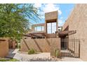Modern exterior featuring stucco walls, pergola, gated entry, and unique architectural design at 7401 N Scottsdale Rd # 24, Paradise Valley, AZ 85253