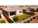 This aerial view highlights the green lawn, private fenced yard, and covered patio of this cozy backyard at 9229 W Willow Bend Ln, Phoenix, AZ 85037