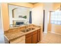 Open kitchen featuring granite countertops, stainless steel sink, and breakfast bar seating area at 930 N Mesa Dr # 2027, Mesa, AZ 85201