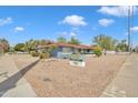 Street view of a charming, single-story residential building with a blue brick facade, xeriscaping, and well-maintained landscaping at 140 W University Dr, Mesa, AZ 85201